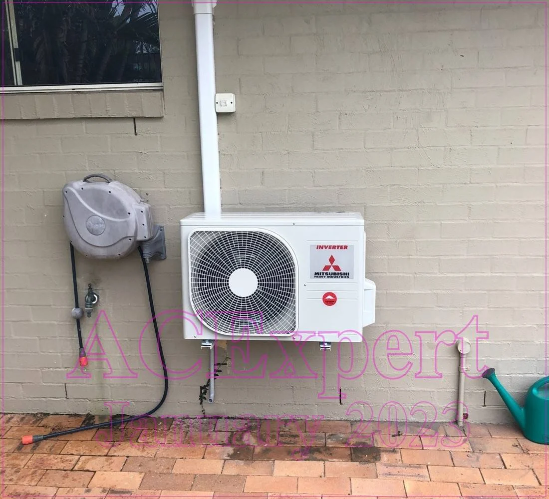 Technician installing a split system air conditioner in a Melbourne restaurant with an open kitchen setup